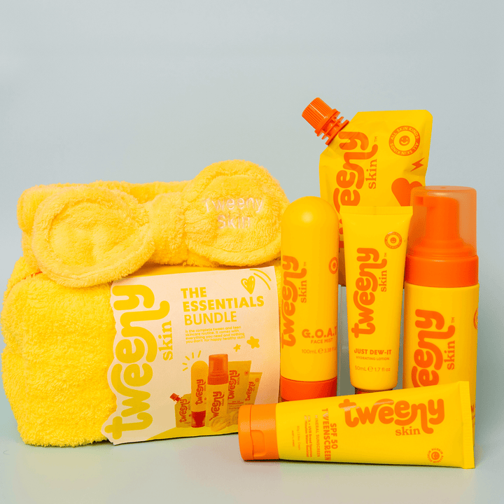 Product image of the Tweeny Skin Essentials Bundle — a vibrant skincare set for tweens and teens, featuring six gentle, fragrance-free essentials: FOAM-O Gentle Cleanser, TweenScreen SPF50 Mineral Sunscreen, Just Dew-It Hydrating Lotion, G.O.A.T. Face Mist, Multi-Masker Turmeric Clay Mask, and a soft yellow Tweeny Skin towel bag with matching headband. Created specifically for young, sensitive skin, this all-in-one bundle promotes healthy skincare habits in a fun, beginner-friendly way.